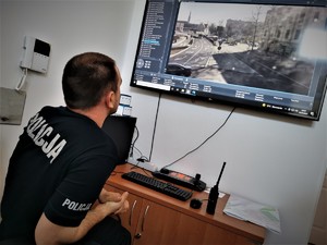 policjant ruchu drogowego przegląda miejski monitoring pod kątem bezpieczeństwa pieszych