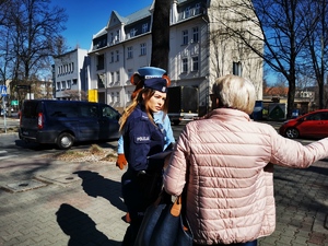 policyjna maskotka wraz z policjantką rozmawiają z przechodniami w centrum miasta