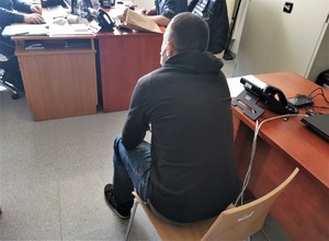 mężczyzna siedzący na krześle, w kierunku okna, w tle biurko
