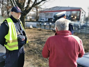 kontrola kierującego. Widać mężczyznę w czerwonym polarze oraz funkcjonariusza straży ochrony kolei