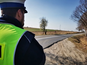 policjant drogówki wypatrujący samochodu