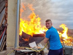 zdjęcie kolorowe: nieumundurowany policjant gaszący pożar