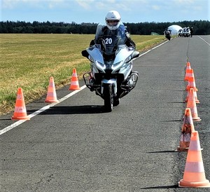 uczestnik szkolenia jedzie motocyklem, tor jazdy, ustawione wzdłuż toru pachołki