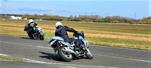 policjanci w trakcie szkolenia z jazdy motocyklem, tor jazdy, uczestnicy wykonują slalomy