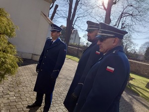 trzech policjantów w mundurach wyjściowych stoi przed tablicą upamiętniającą pomordowanych policjantów. Mikołów, dzielnica Bujaków