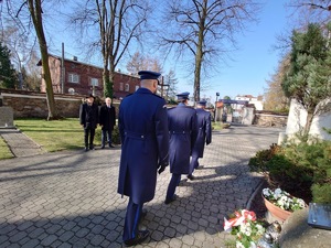 Policjanci odchodzą w kierunku bramy tuż po oddaniu hołdu