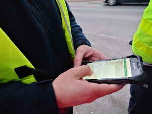 policjant wykonuje sprawdzenie w systemie na urządzeniu mobilnym