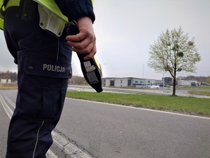 policjant drogówki trzyma w ręce urządzenie - tak zwana kukurydza