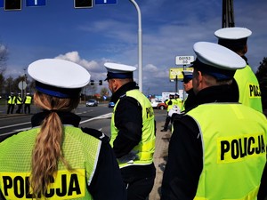 stojący w grupie policjanci ruchu drogowego. Wszyscy mają założone odblaskowe kamizelki