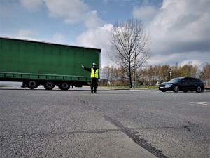 policjant drogówki kieruje ruchem na skrzyżowaniu w Mikołowie. Obok niego przejeżdżają auta