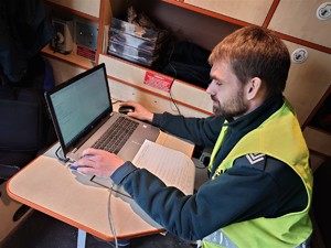 funkcjonariusz transportu drogowego dokonuje kontroli tachografu podpiętego do laptopa