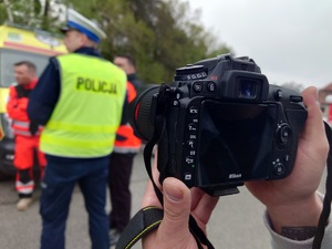 mężczyzna robi zdjęcie ratownikom medycznym i policjantowi