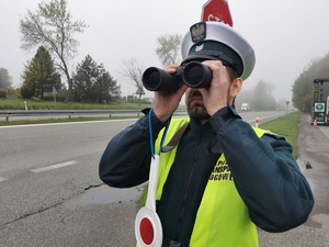 funkcjonariusz transportu drogowego patrzy przez lornetkę