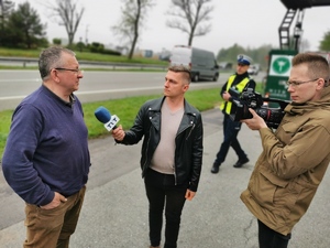 przedstawiciele telewizji rozmawiają z kierowcą