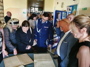 policjanci wraz z innymi gośćmi przeglądają wystawę zbiorów placówki