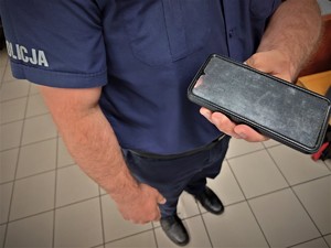 policjant trzyma w dłoni odzyskany telefon