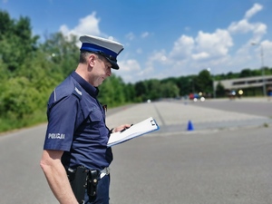 policjant drogówki czyta plan zabezpieczenia