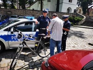 policjanci drogówki rozmawiają z rowerzystą