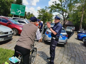 policjanci drogówki rozmawiają z rowerzystą