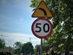 znak drogowy: ograniczenie do 50 kilometrów na godzin oraz znak zakrętu