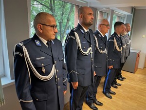 stojący w rzędzie policjanci w mundurach galowych