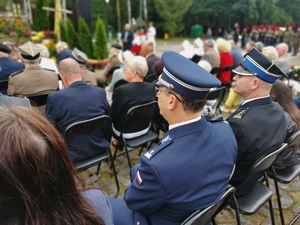 komendant policji siedzi na krześle wraz z innymi uczestnikami