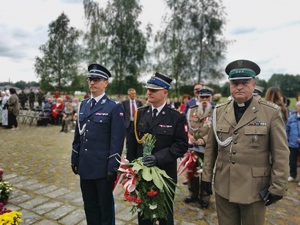 delegacja zmierzająca w kierunku pomnika, wśród nich komendant Policji