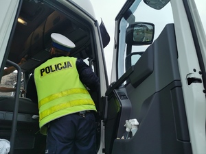 policjant drogówki wchodzi do kabiny ciężarówki