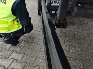 policjant sprawdza podwozie samochodu