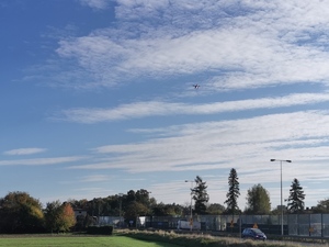 zdjęcie kolorowe: fragment nieba, a na nim widać latający dron