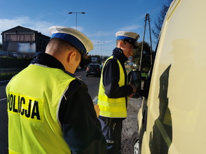 policjanci drogówki w odblaskowych kamizelkach kontrolują kierowcę busa