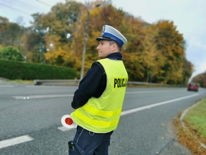 Policjant drogówki stoi przy trasie drogi krajowej numer 44