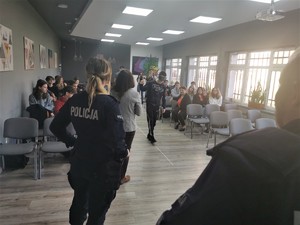 młodzież szkolna podczas zajęć praktycznych. Scena ma miejsce w budynku szkoły. Na zdjęciu widać też policjantkę