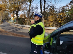 policjant i strażnik miejski stoją przy radiowozie