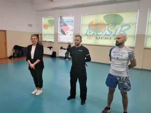 sala gimnastyczna: instruktor sportów walki, policjant i dyrektorka ośrodka