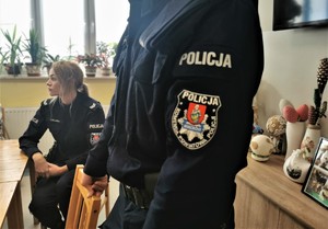 zbliżenie na naszywkę policyjnego munduru. W tle policjantka