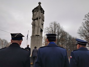 delegacja przedstawicieli władz stojąca przed pomnikiem