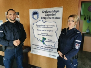 policjantka i policjant prezentują plakat aplikacji Krajowa Mapa Zagrożeń Bezpieczeństwa