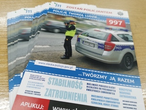 na zdjęciu widać położone na stole ulotki z informacjami o rekrutacji do służby w Policji