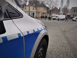 na zdjęciu widać fragment policyjnego radiowozu, w tle przechodnie, centrum Mikołowa