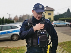 na zdjęciu policjant patrolu orzeskiej jednostki Policji, który stoi przed budynkiem komisariatu