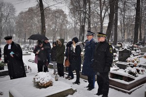 na zdjęciu widać cmentarz, osoby oddają hołd zmarłemu, jest dużo śniegu