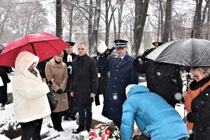 na zdjęciu widać oddającego hołd zmarłemu komendanta policji