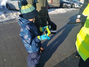 na zdjęciu widać małego chłopca, obok niego policjant z odblaskami