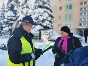 na zdjęciu widać policjantkę wręczającą odblask starszej kobiecie