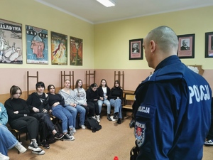 na zdjęciu widać policjanta, który rozmawia z uczniami w jednej z klas szkolnych