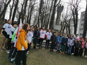 na zdjęciu widać uczestników biegu pod pomnikiem w Mikołowie