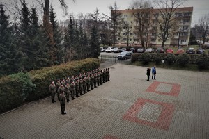 plac przed budynkiem szkoły, uczniowie robią pokaz musztry