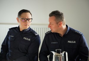 na zdjęciu widać rozmawiających ze sobą dwóch policjantów