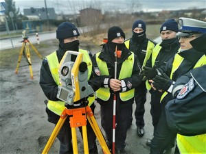 na zdjęciu widać policjantów drogówki, którzy stoją obok siebie podczas szkolenia z urządzenia zwanego tachimetrem